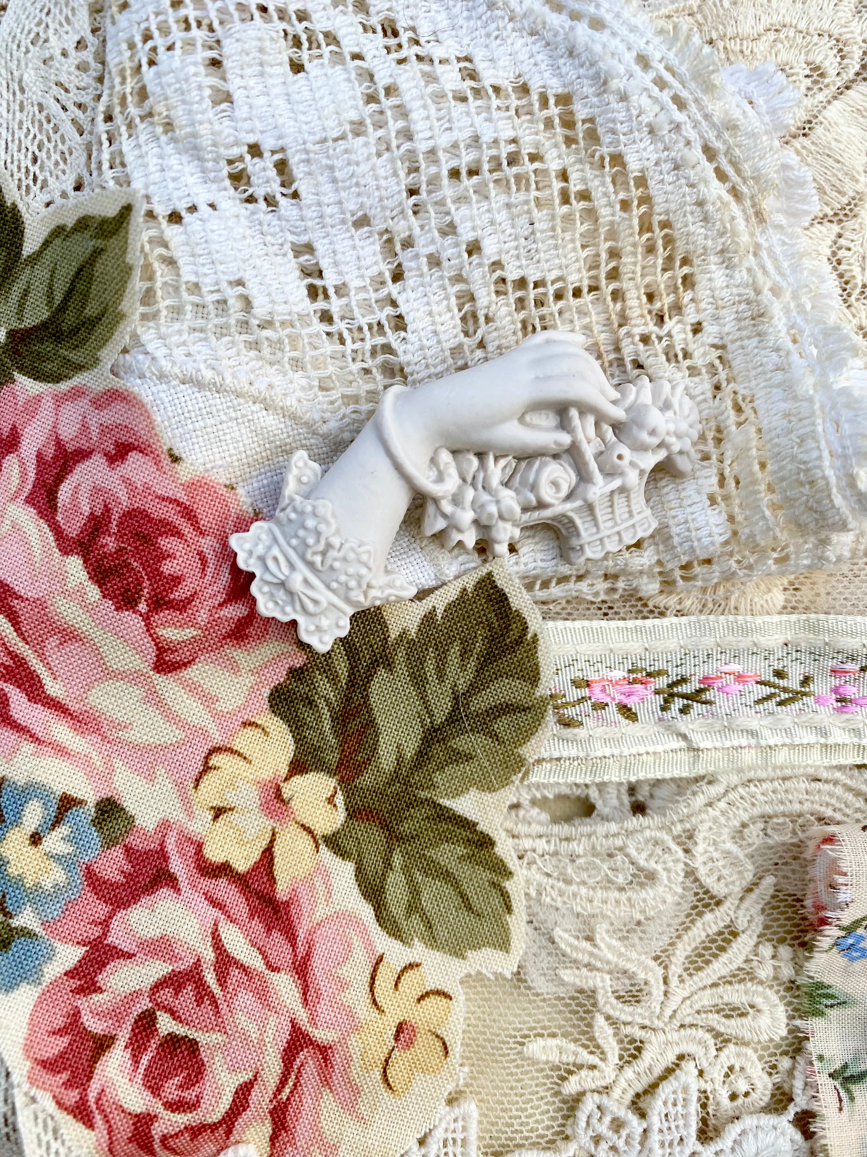 Resin Edwardian hand brooch holding a basket of flowers.